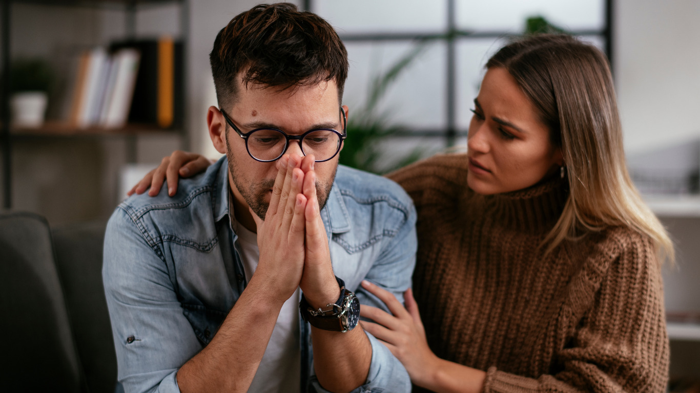 Distraught father being comforted by mother