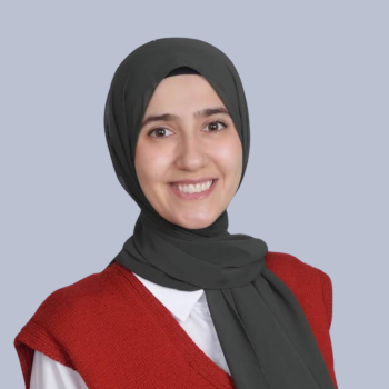 Picture of Dr. Zeynap Ozdener headshot in a red sweater and beautiful grey headwrap